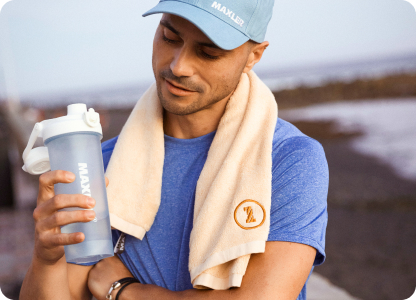 A man in a blue cap drinking protein