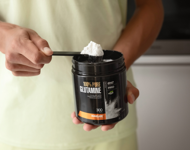 A man taking a scoop of glutamine from 100% Pure Glutamine can
