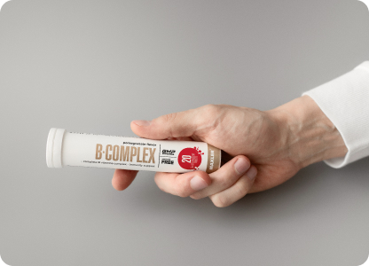 A hand holding a B-Complex Effervescent Tablets tube