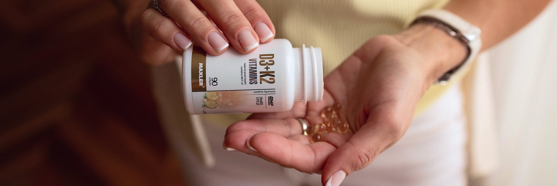 A woman pouring softgel capsules on her hand