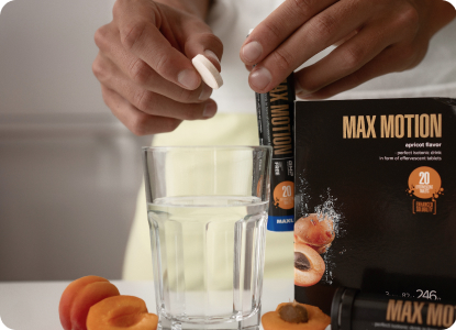 A tablet of Max Motion Effervescent being put into a glass