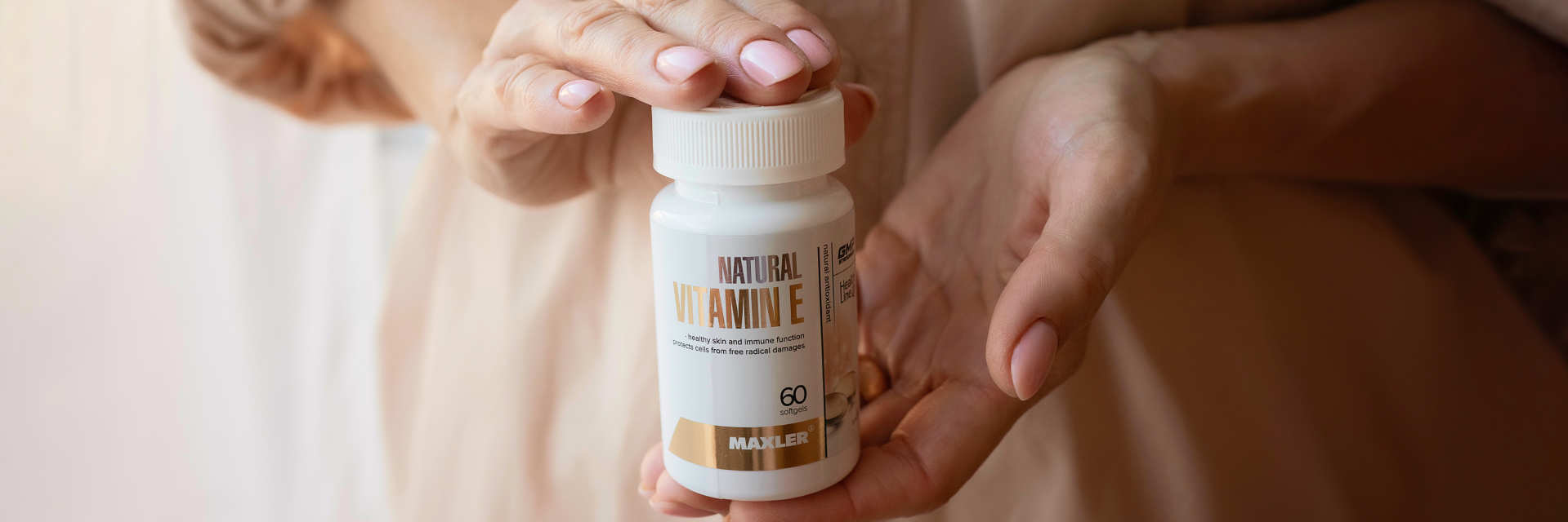 Woman's hand holding a bottle of Natural Vitamin E