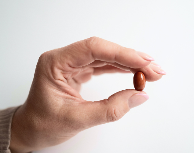 A hand holding Coenzyme Q10 capsule